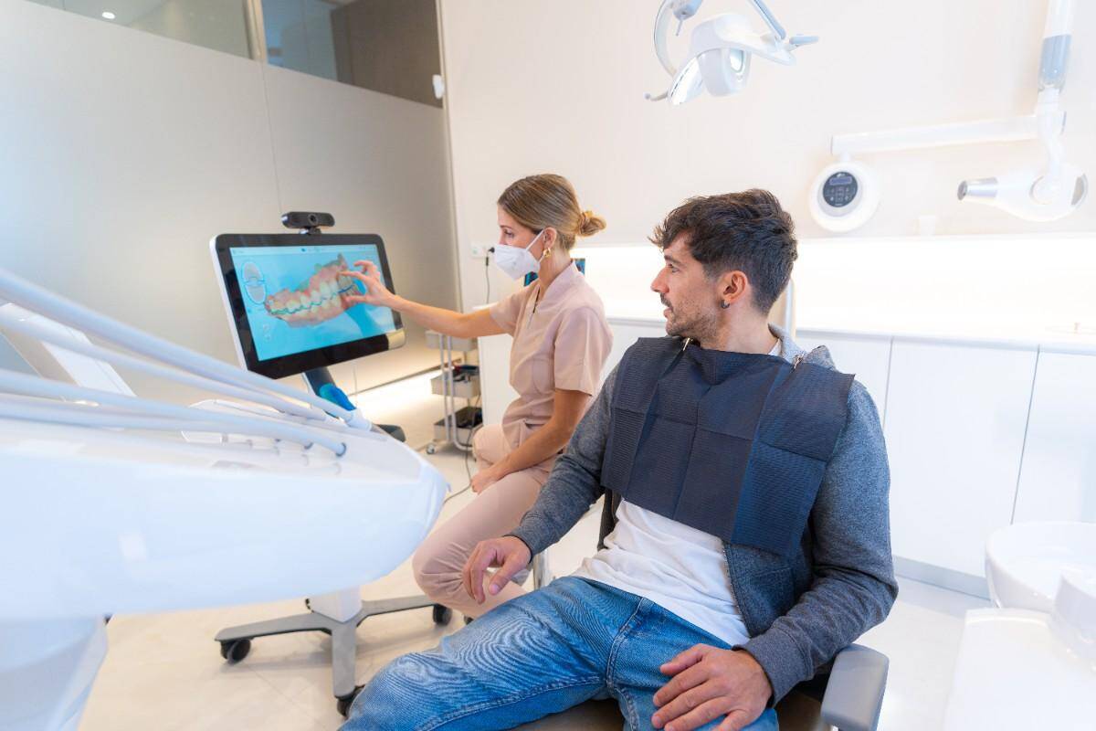 Dentist showing digital smile design to patient in modern clinic