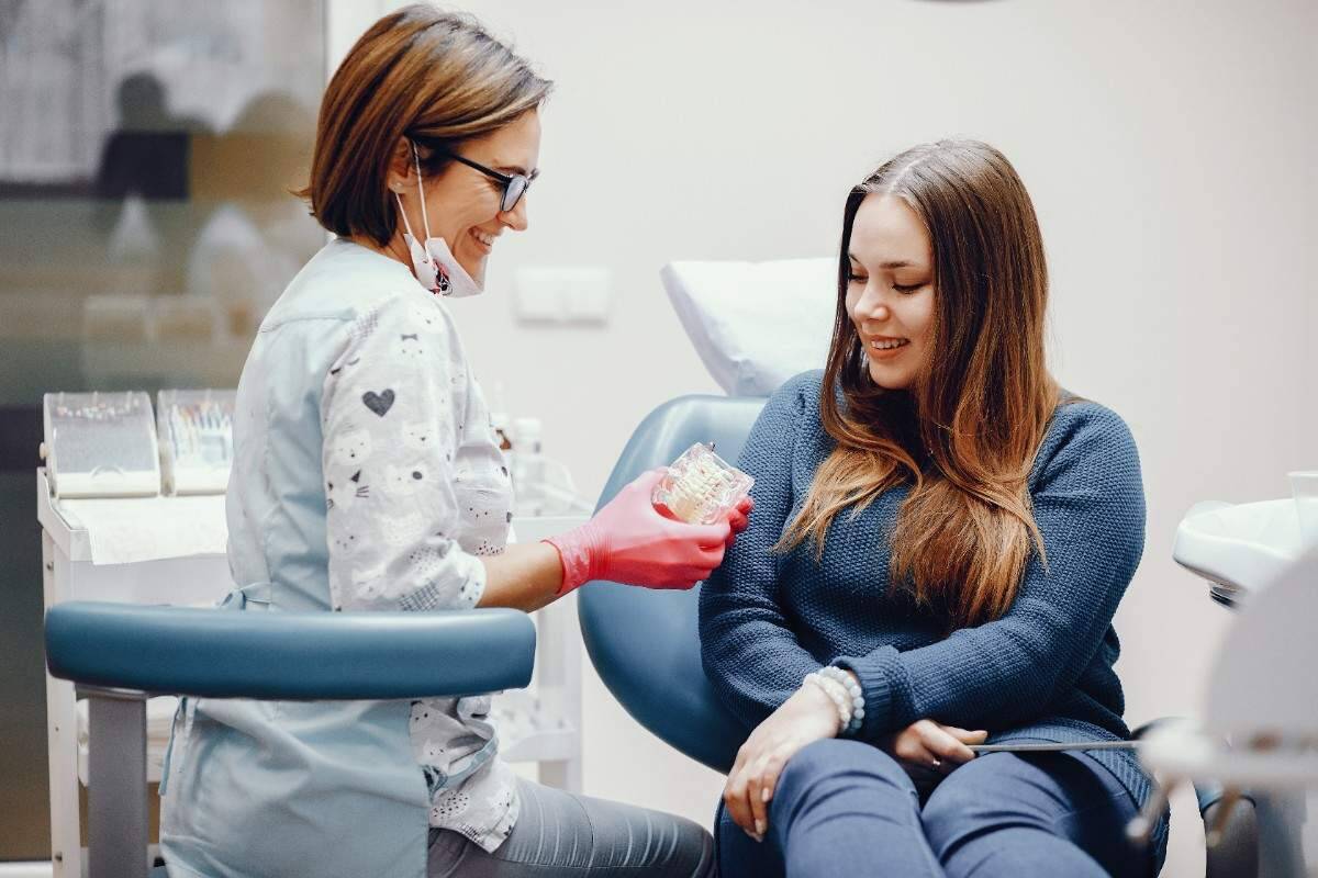 Dentist showing dental model to patient in clinic