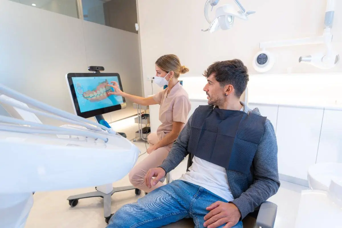 Dentist showing digital smile design to patient in modern clinic