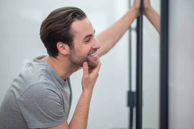 Man checking his teeth in a mirror